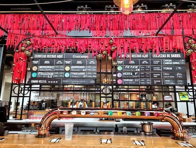 Bar principal con decoración festiva y menú de cervezas Cruzcampo
