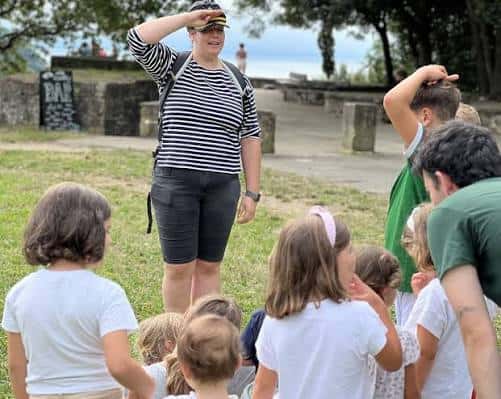 Guía explicando a un grupo de niños en el exterior del parque