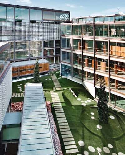 Vista aérea del patio interior con césped y pasarelas del COAM