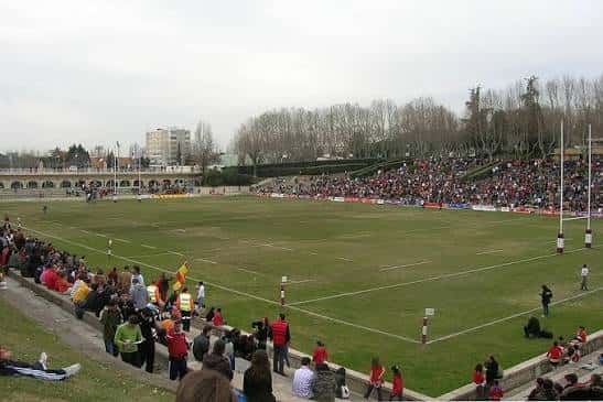 Vista general del campo de rugby con gradas llenas de espectadores durante un partido