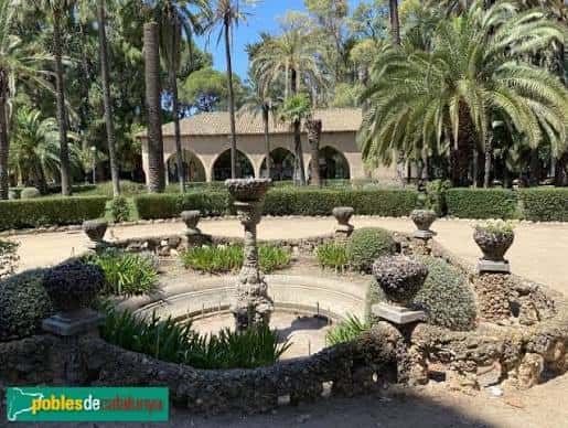 Jardín formal con fuentes ornamentales y palmeras en primer plano