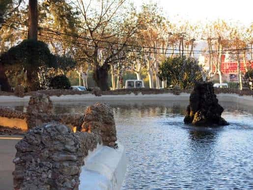 Vista del estanque con rocas y árboles al atardecer