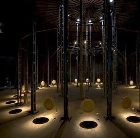 Interior del espacio con iluminación dramática y elementos circulares suspendidos
