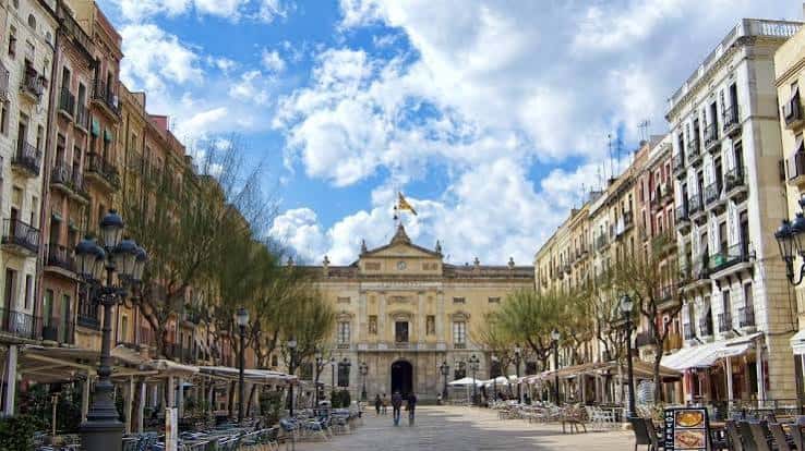 Plaza del Tarragonès con edificios históricos y banderas catalanas