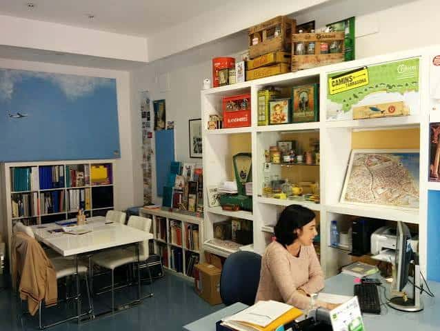 Interior de la oficina de Itinere con estanterías de libros y material turístico