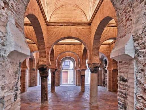 Vista interior de la sala principal con arcos de ladrillo y columnas de piedra