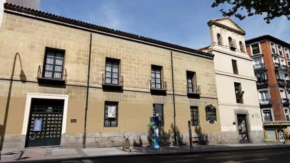 Fachada principal de la Sociedad Cervantina en Madrid, edificio histórico de piedra con ventanas y balcones