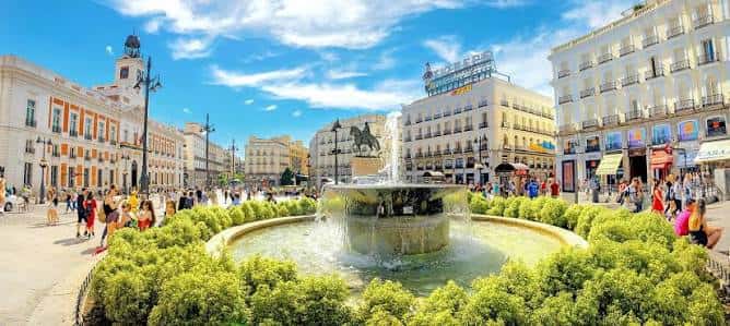 Plaza de la Puerta del Sol con la fuente iluminada y el monumento a Carlos III al fondo