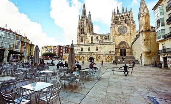 Vista panorámica de la Plaza del Rey San Fernando con la Catedral de Burgos al fondo y mesas de terraza en primer plano