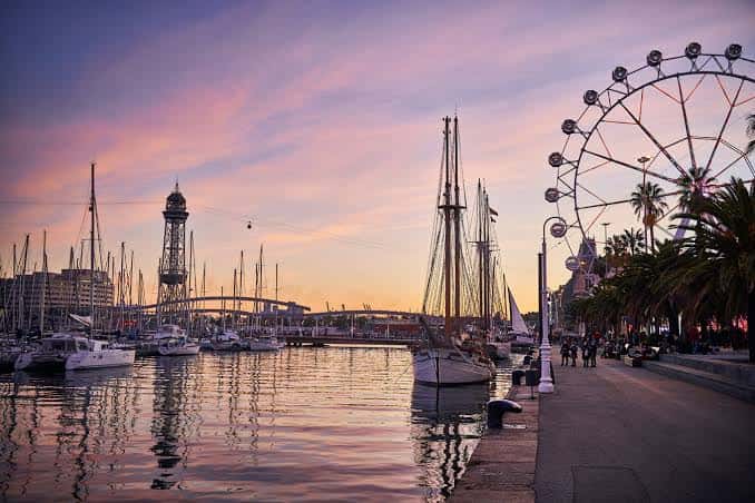 Atardecer en el Puerto Viejo con la noria y veleros reflejados en el agua