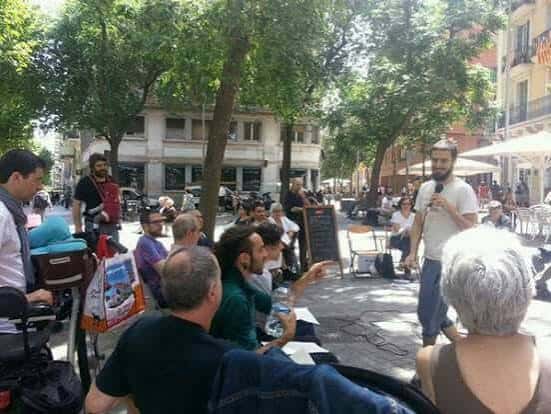 Evento al aire libre en la Plaça dels Ocellets con público y orador