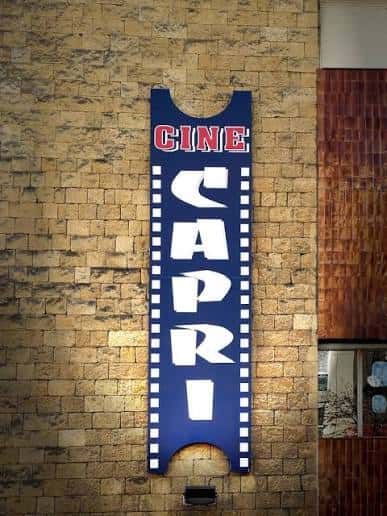 Detalle de la fachada del Cine Capri con su icónico letrero vertical azul y blanco