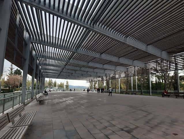 Interior de la estructura de sombra en la Rambla del Ferrocarril con bancos y vegetación