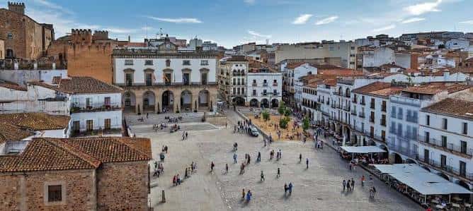 Vista panorámica de la Plaza Mayor de Cáceres con edificios históricos y gente caminando