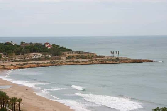 Panorámica de la playa y el acantilado de Punta del Miracle con el puerto al fondo