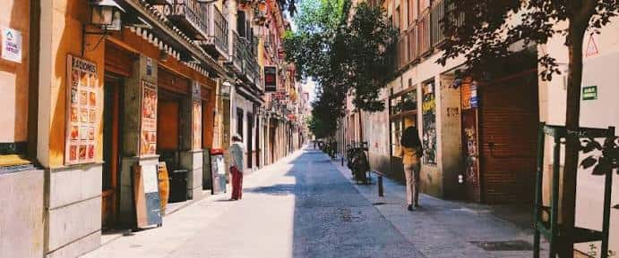 Calle peatonal con edificios de estilo tradicional y árboles en Alcorcón
