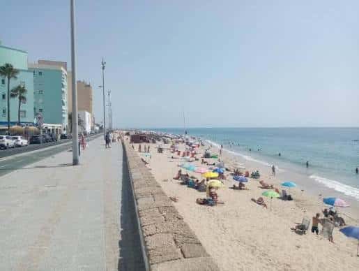 Paseo marítimo de Cádiz con gente disfrutando de la playa y el mar