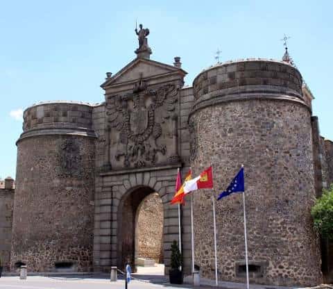 Puerta Nueva de Bisagra en Toledo con banderas y cielo despejado