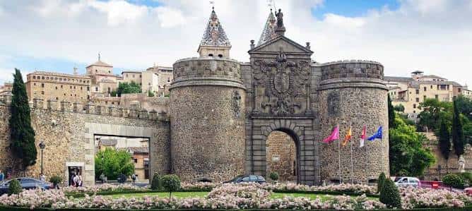 Vista panorámica de la Puerta Nueva de Bisagra con jardines y edificios históricos al fondo