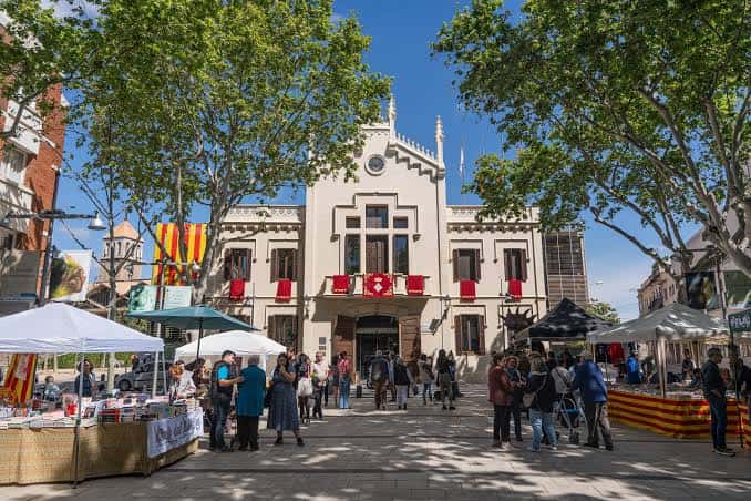 Vista general de la Plaça de Sant Jordi durante una celebración con puestos de libros y flores