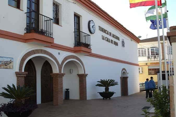 Detalle de la entrada principal con arcos y banderas de España, Andalucía y la Unión Europea
