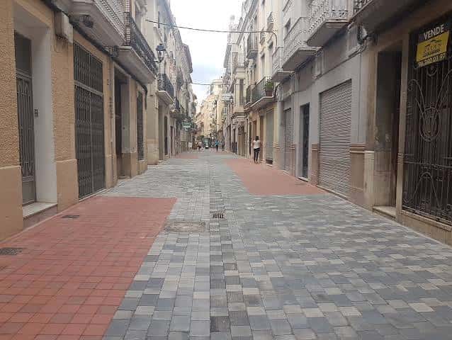 Vista de la calle peatonal con adoquinado y edificios residenciales