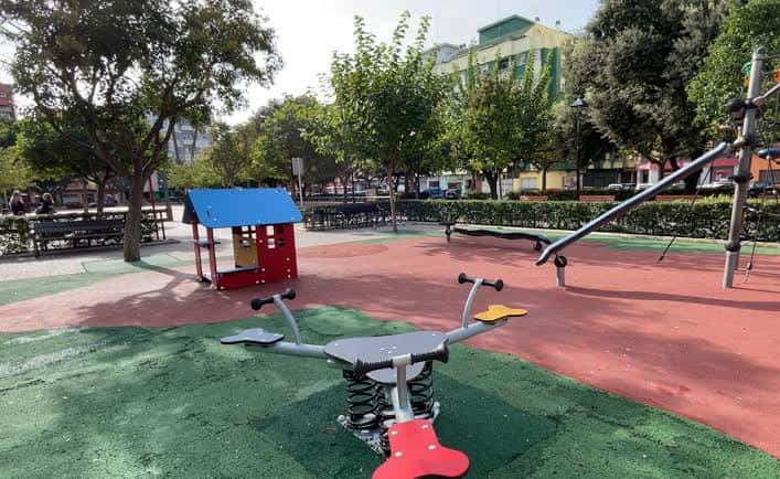 Zona de juegos infantiles con equipamiento moderno y suelo de goma