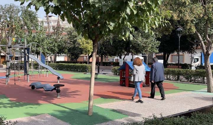 Paseo arbolado junto a la zona de juegos con personas caminando