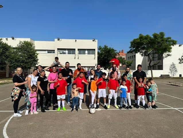 Grupo de estudiantes y profesores posando en el patio del instituto bajo un día soleado