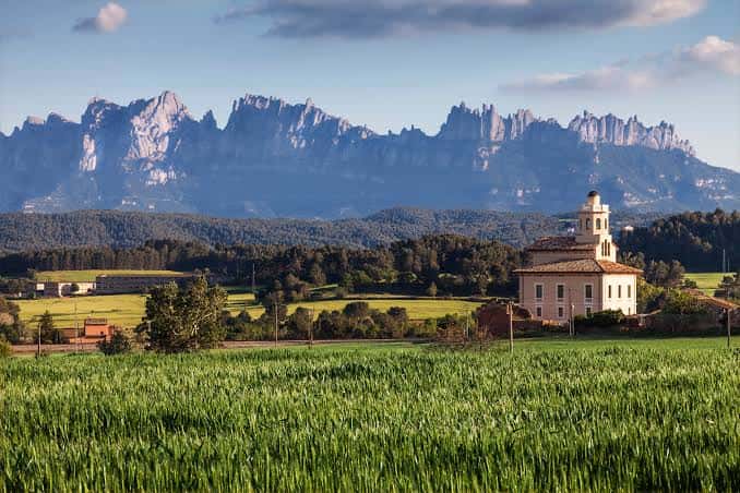 Torre Lluvià en primer plano con la imponente silueta de Montserrat al fondo