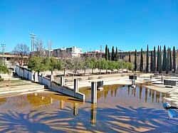 Paisaje del parque con reflejos en el agua y cielo despejado