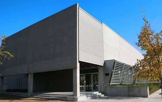 Vista exterior del Pavelló Municipal de Can Bassa con fachada de hormigón y cielo azul