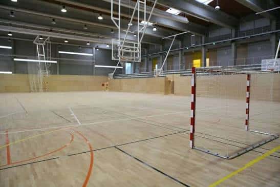 Vista del interior del pabellón con portería de balonmano y canastas