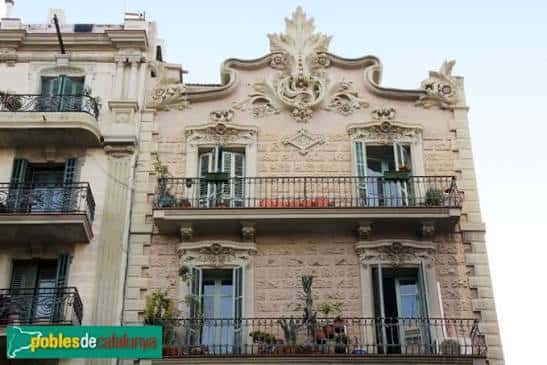 Detalle de la parte superior de la fachada con ornamentación y balcones