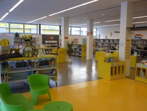 Interior de la biblioteca con zona infantil y estanterías coloridas