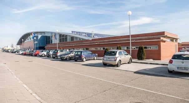 Vista exterior del complejo deportivo Las Cumbres con estacionamiento