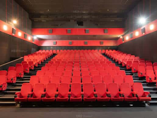 Sala de cine con butacas rojas y decoración en tonos rojos y negros