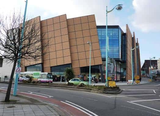 Vista exterior del centro comercial Drake Circus con fachada moderna de paneles de cerámica y cristal