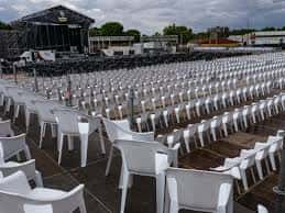 Vista del auditorio al aire libre con filas de sillas blancas y escenario en el Recinto Ferial de Badajoz