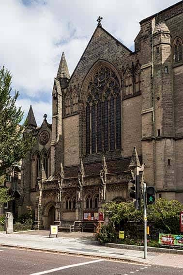 Fachada lateral de la iglesia con detalles arquitectónicos góticos y ventanales ornamentados