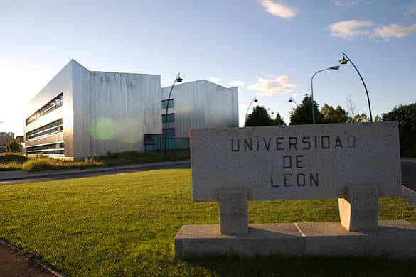 Fachada moderna de la Universidad de León con letrero de piedra en primer plano