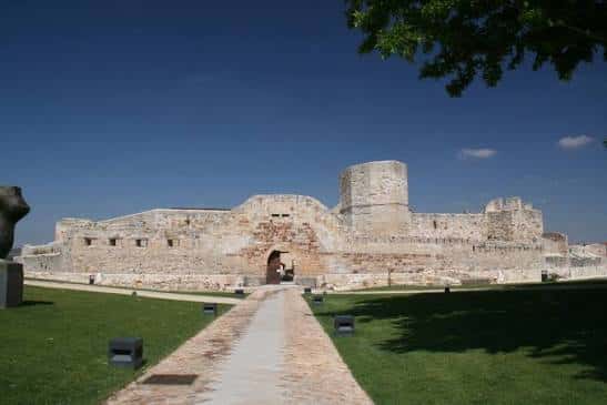 Vista panorámica del Castillo de Zamora con césped y camino central bajo cielo azul