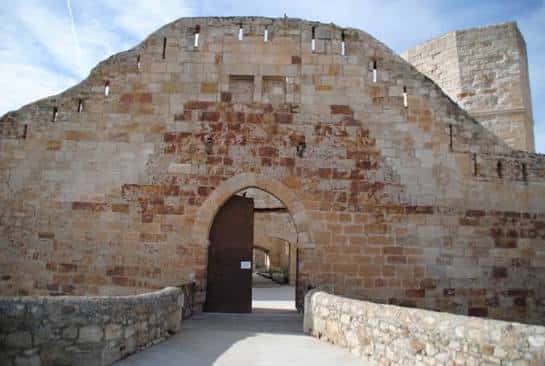 Detalle de la puerta de acceso al castillo con muros de piedra y cielo despejado