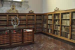 Sala histórica de la Biblioteca de San Isidoro con estanterías de madera y libros antiguos