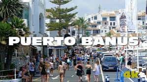Calle concurrida de Puerto Banús con arquitectura blanca y palmeras
