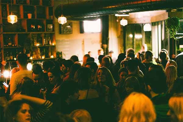 Interior del club Heartbreakers con ambiente festivo y gente socializando