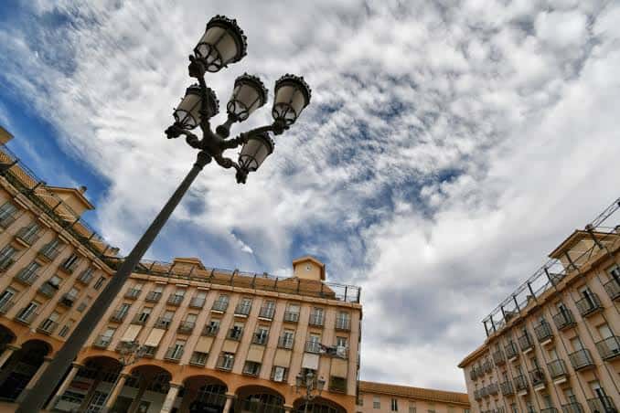 Detalle de la farola histórica en la Plaza Mayor de Elda con cielo dramático