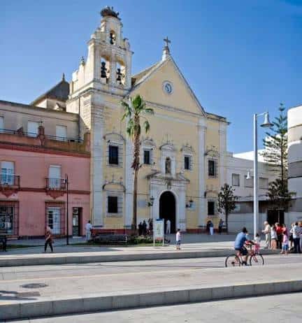 Fachada diurna de la Iglesia del Carmen con plaza y transeúntes