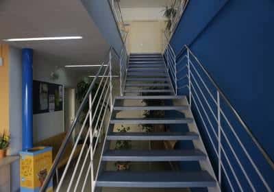 Escalera interior con barandillas metálicas y paredes azules