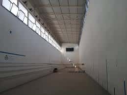 Vista interior del pabellón de exposiciones con grandes ventanales y espacio diáfano